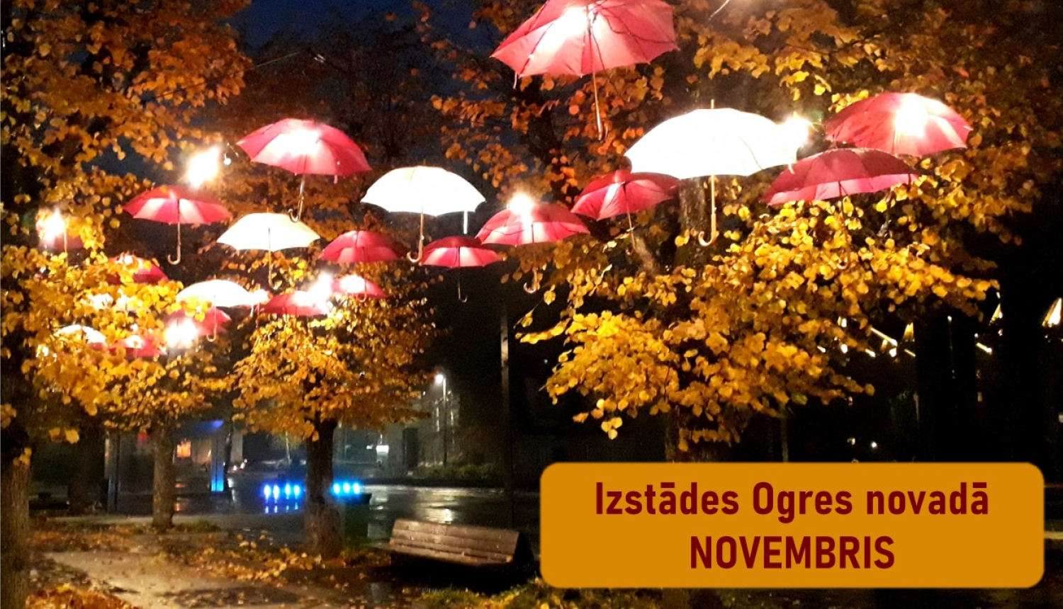 Lietussargi sarkani un balti kā valsts karogs starp kokiem