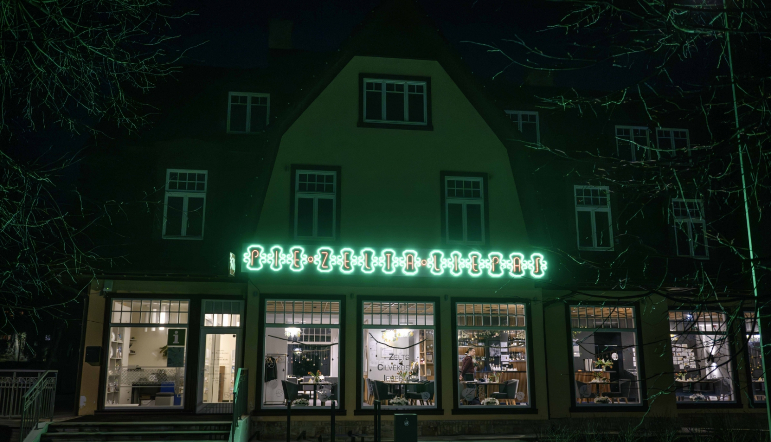 Ēka ar mirdzošu uzrakstu ar "Pie Zelta liepas"