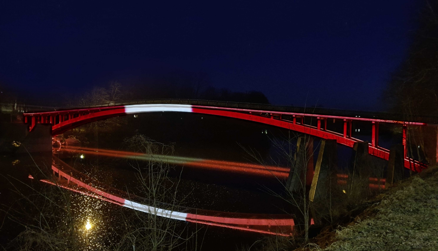 Tilts pār Ogres upi izgaismots Latvijas karoga krāsās