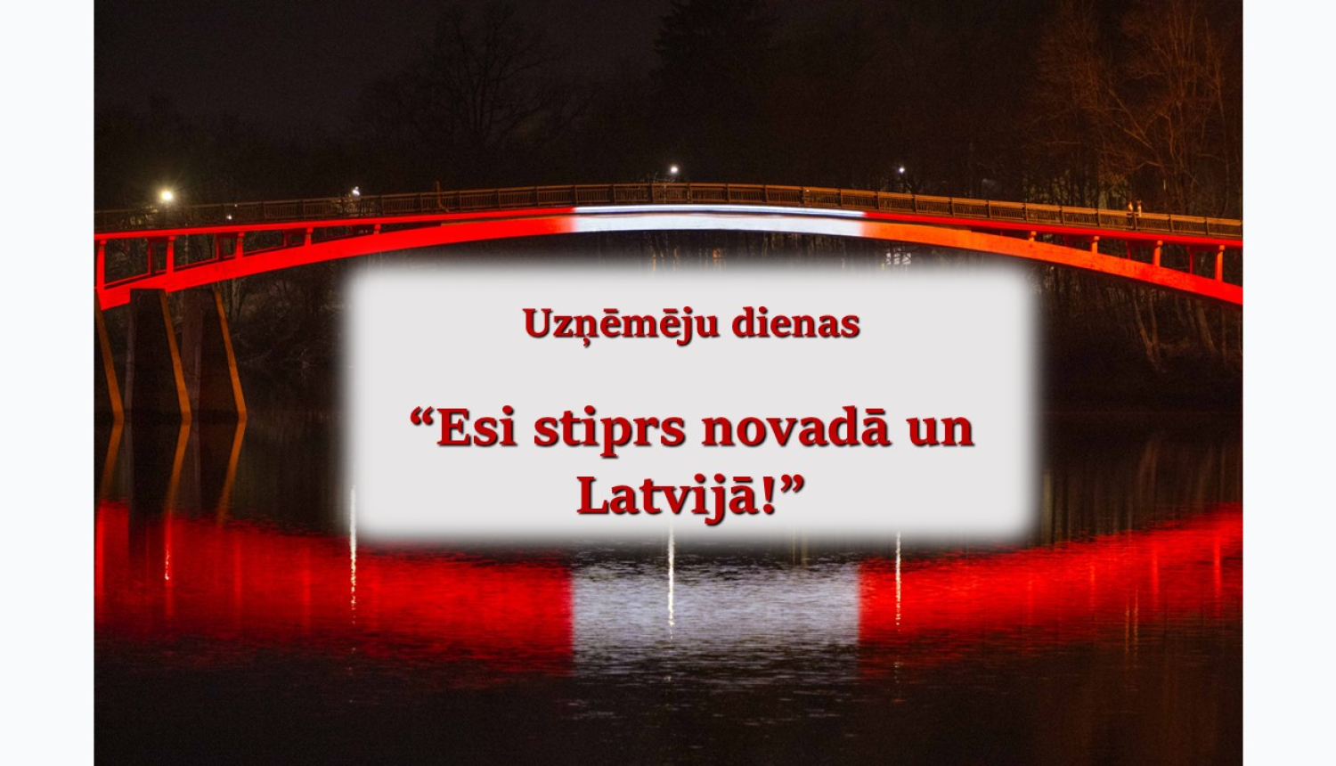 Latvijas karoga krāsās izgaismots gājēju tilts tumsā