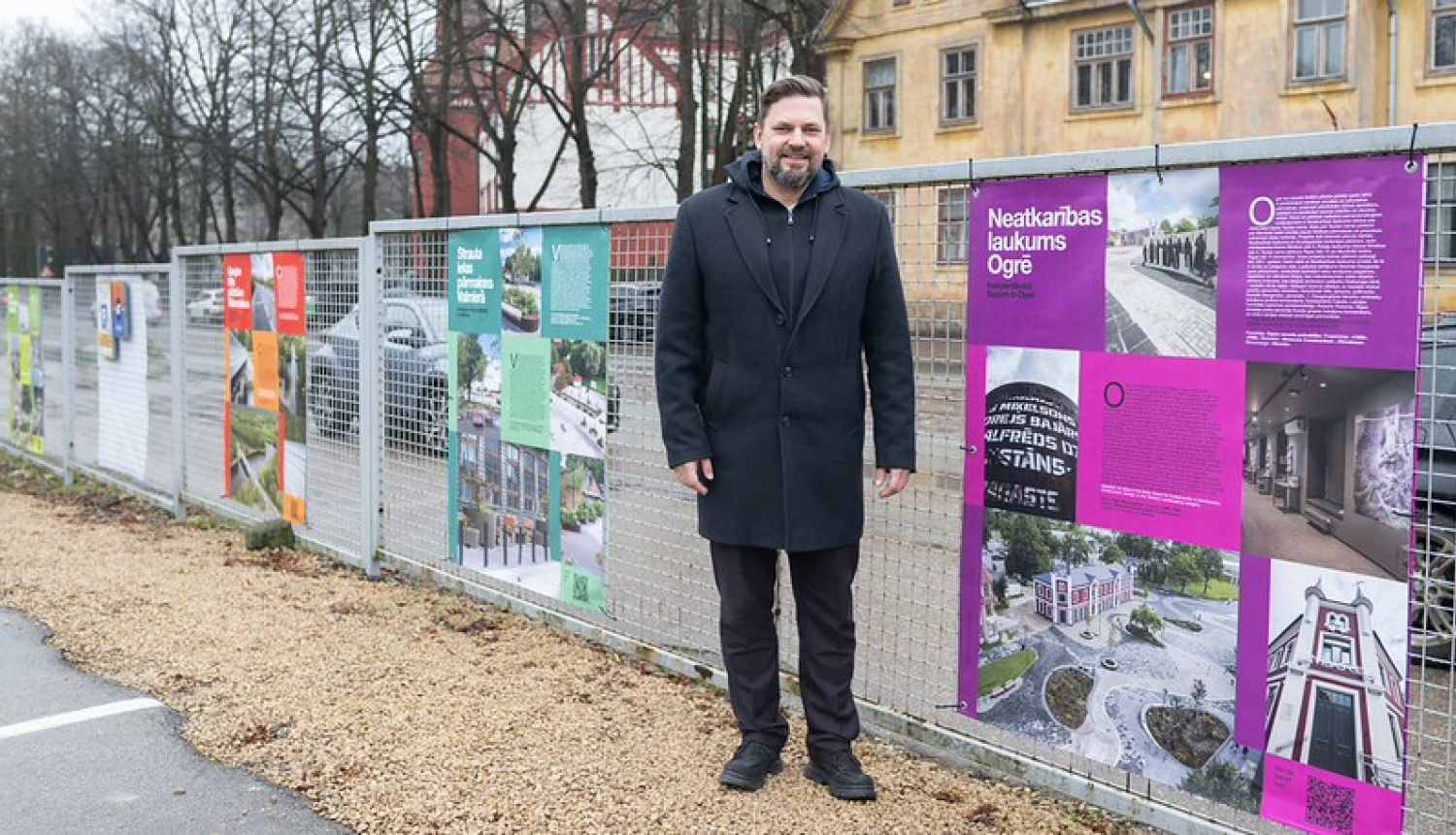 Ogres novada pašvaldības domes priekšsēdētāja vietnieks A. Krauja lielformāta izstādes atklāšanā pie Neatkarības laukuma plakāta