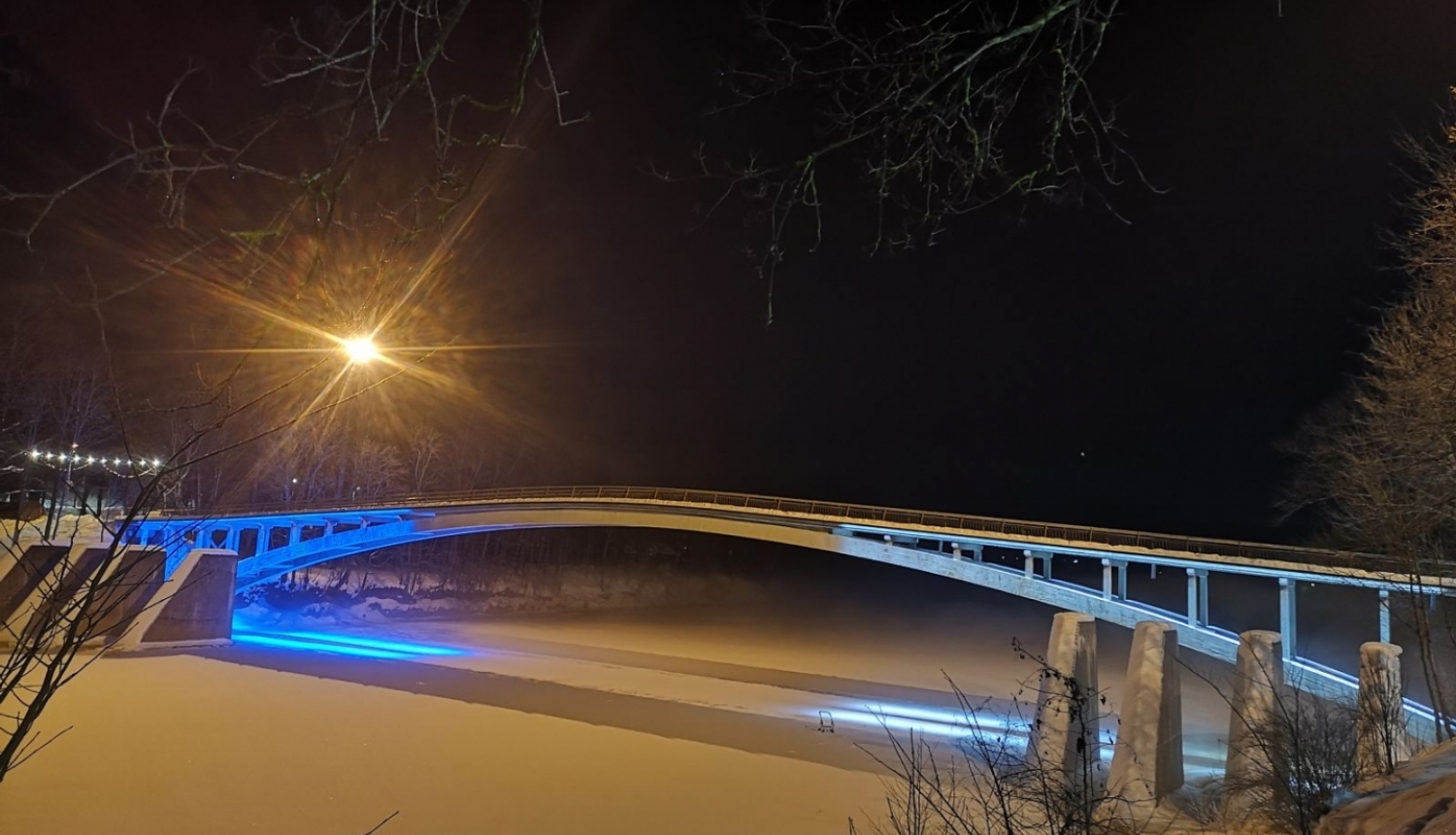Igaunijas karoga krāsās izgaismots lokveida gājēju tilts