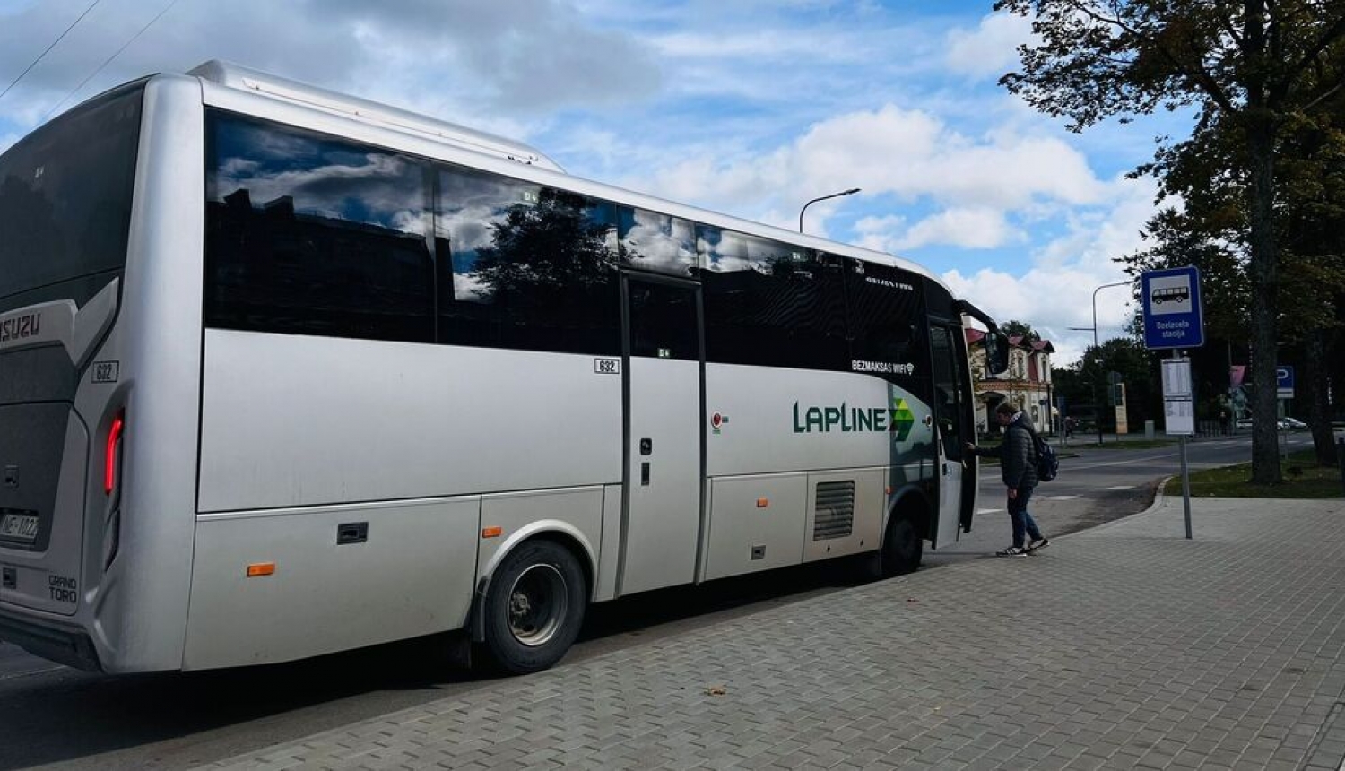 Autobuss pietur pieturvietā, pasažieris iekāpj