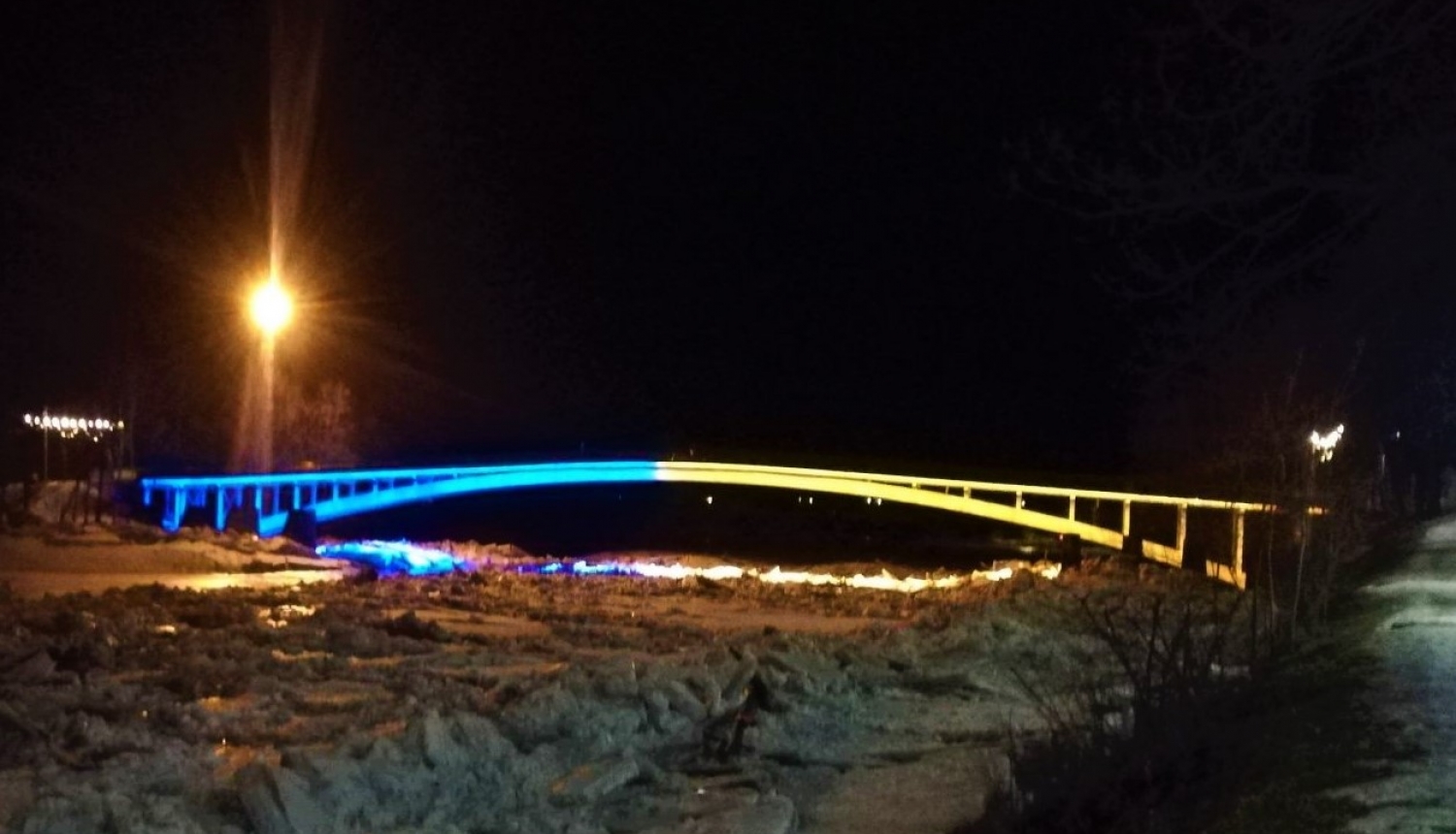 Gājēju tilts pār Ogres upi mirdz Ukrainas karoga krāsās