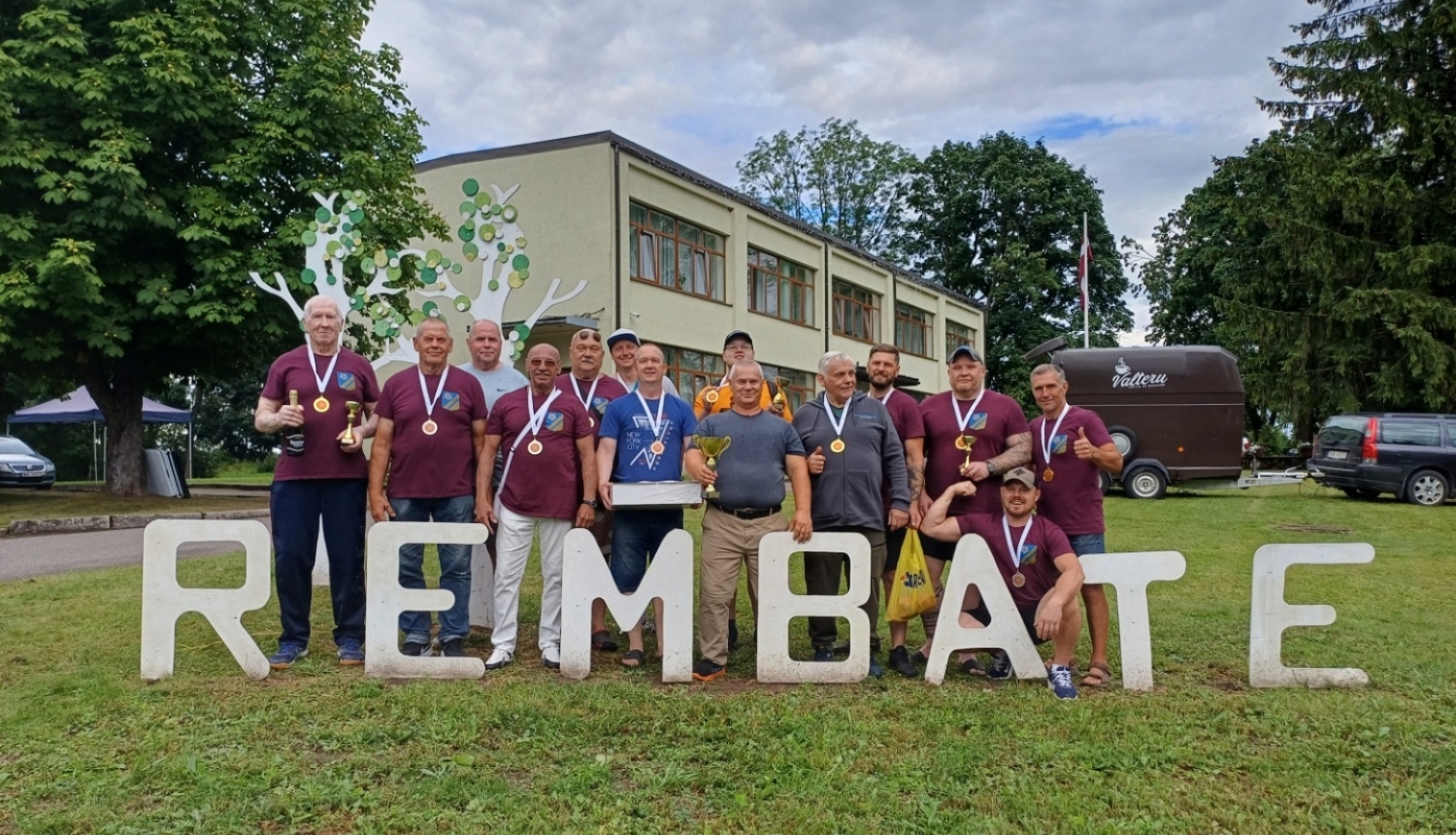 Sportisti stāv pie uzraksta Rembate 20.07.2024.