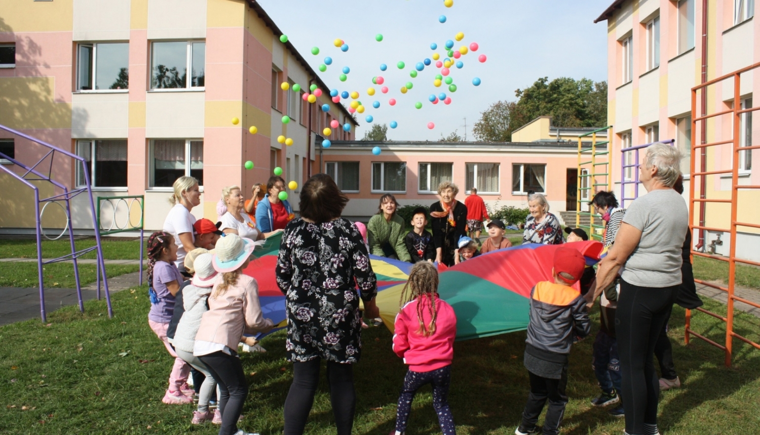 Bērni ar senioriem uz liela auduma met bumbas 09.2024.